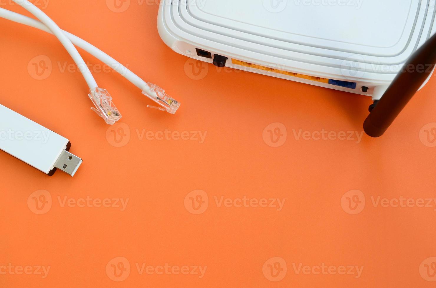 Internet router, portable USB wi-fi adapter and internet cable plugs lie on a bright orange background. Items required for internet connection photo