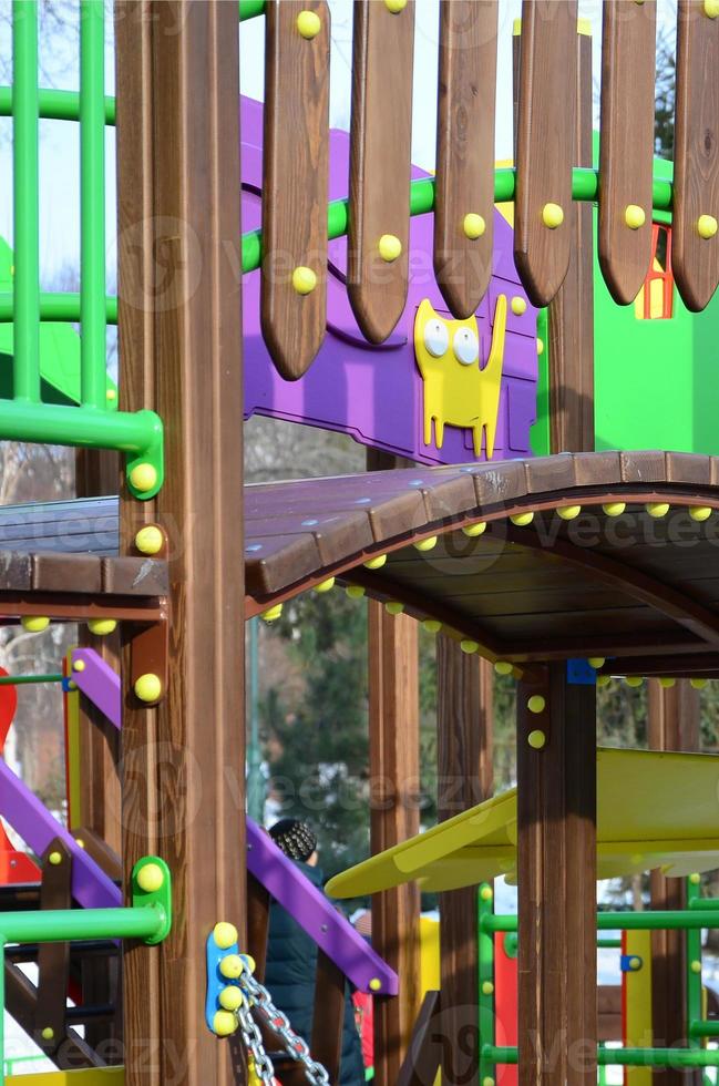 Fragment of a playground made of plastic and wood, painted in different colors photo