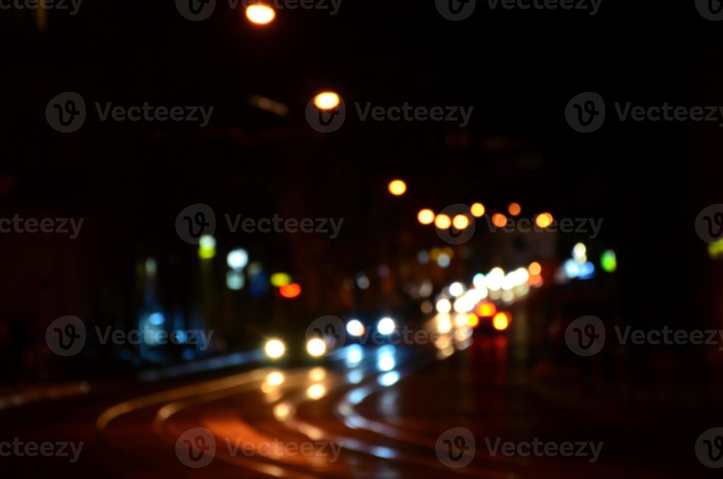 Blurred night scene of traffic on the roadway. Defocused image of cars traveling with luminous headlights. Bokeh Art photo