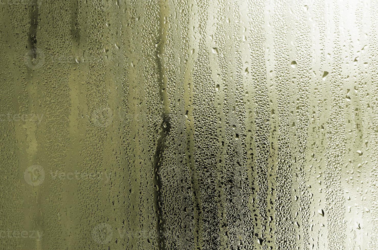 Texture of a drop of rain on a glass wet transparent background. Toned in yellow color photo