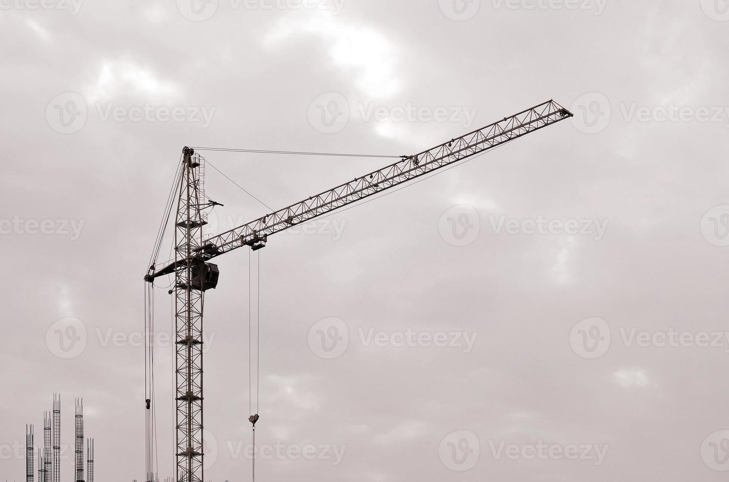 Abstract Industrial background with construction tower cranes over clear blue sky. Construction site. Building under construction concept. Retro tone photo