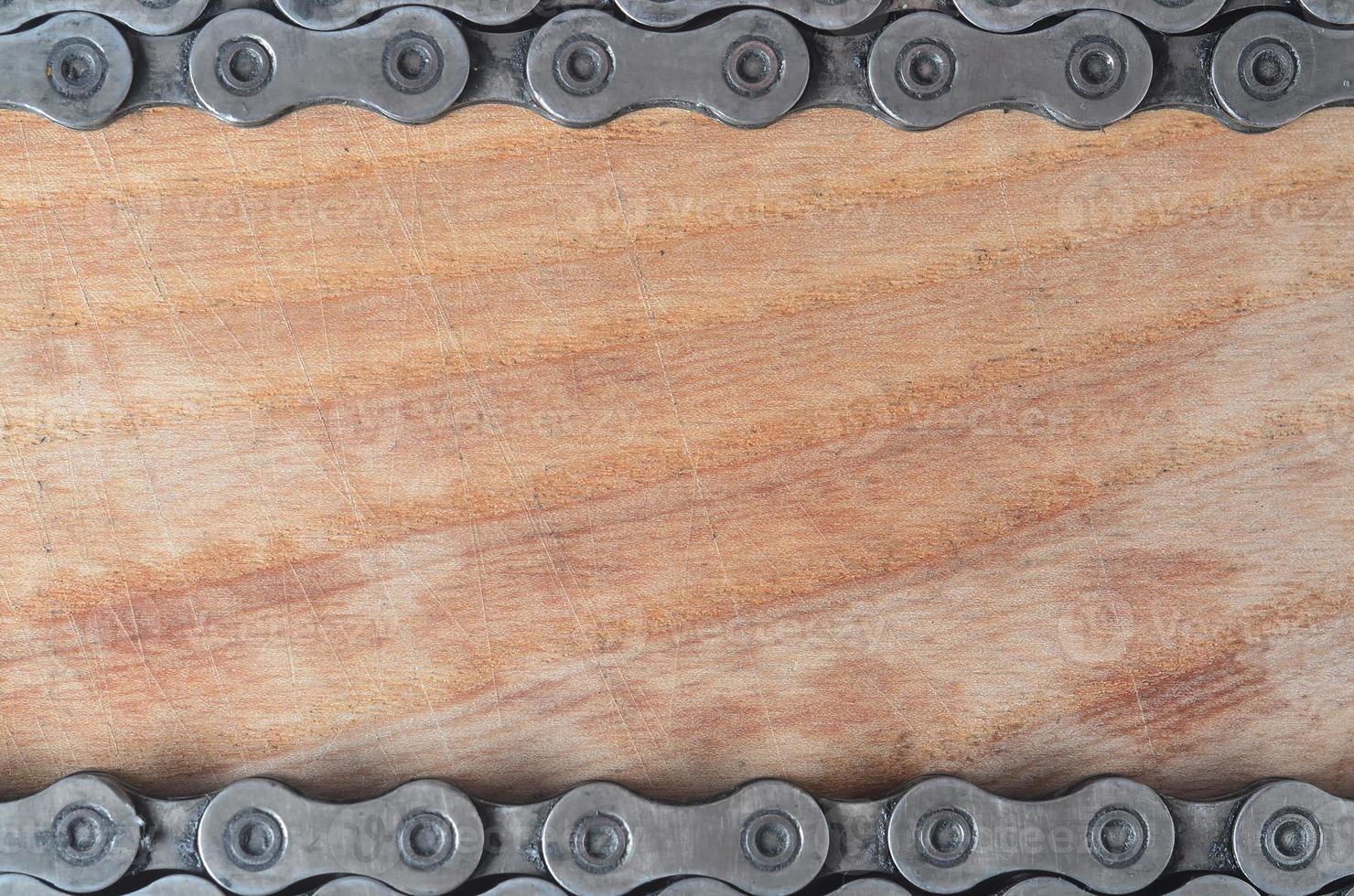 Dirty and oily chain from a mountain bike lying on a wooden table in a bicycle shop photo
