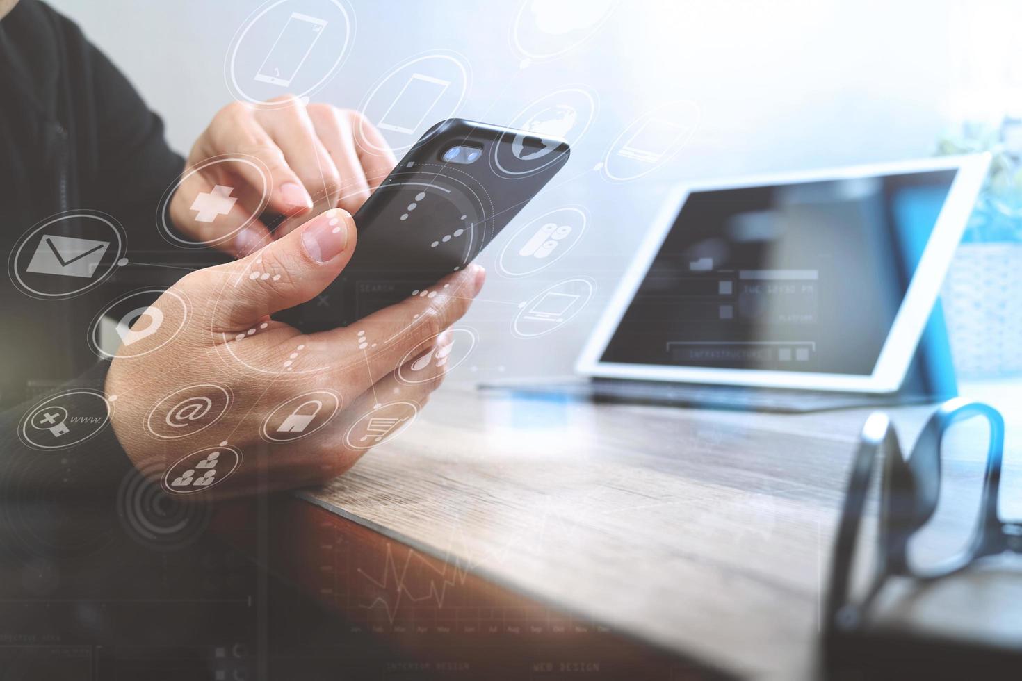 businessman hand using smart phone,mobile payments online shopping,omni channel,digital tablet docking keyboard computer in modern office on wooden desk,virtual interface computer screen photo