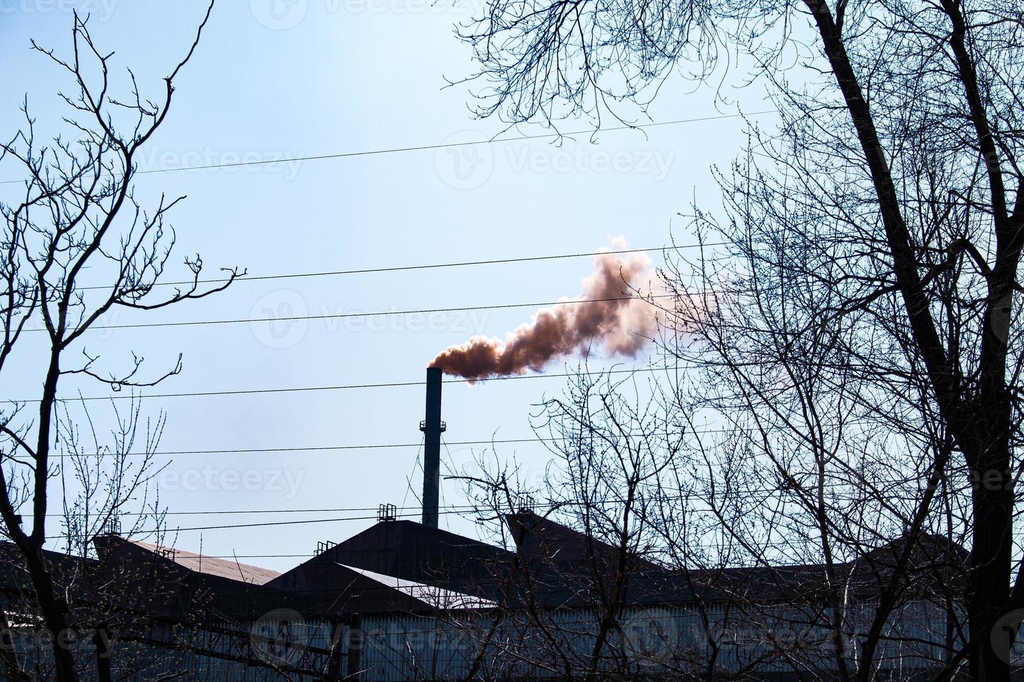 Smoke from the chimney of a chemical plant against the blue sky. The problem of environmental pollution. Ecology concept photo