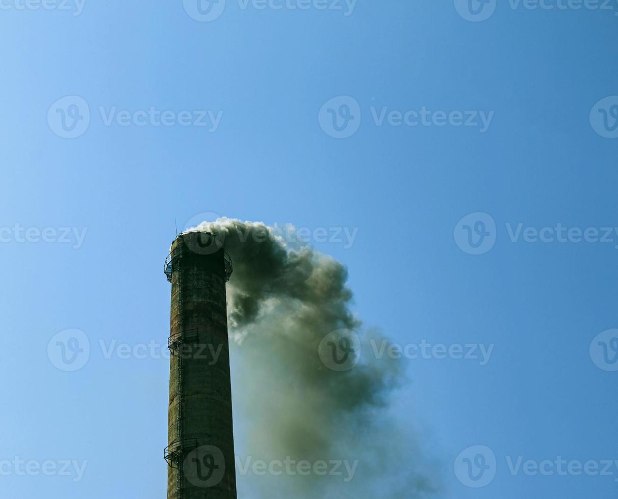 Smoke from the chimney of a chemical plant against the blue sky. The problem of environmental pollution. Ecology concept photo