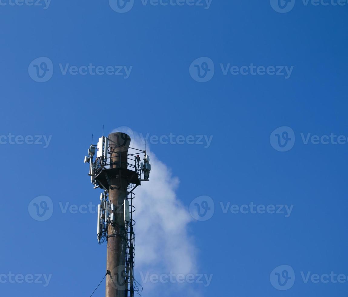 Smoke from the chimney of a chemical plant against the blue sky. The problem of environmental pollution. Ecology concept photo