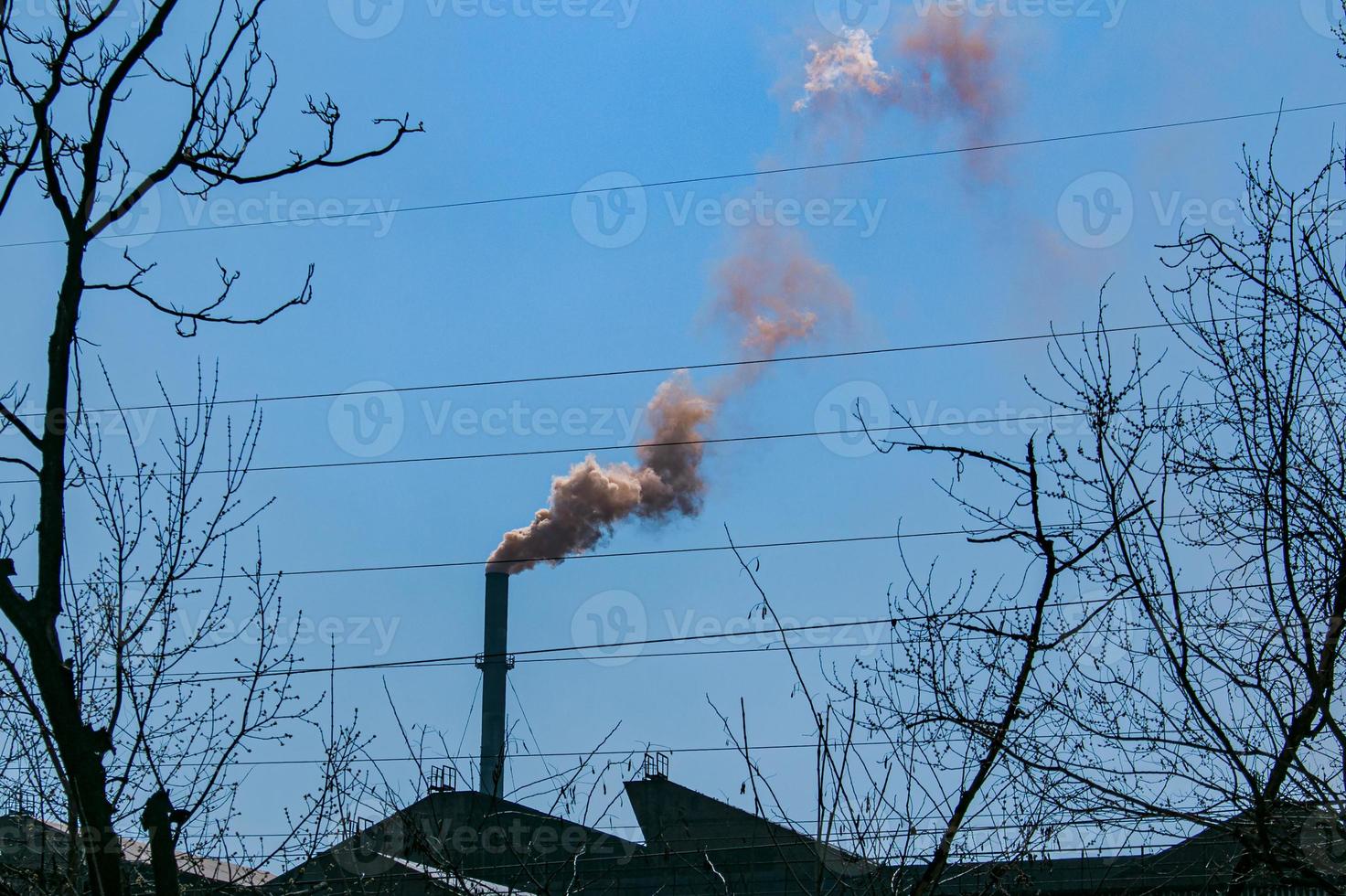 Smoke from the chimney of a chemical plant against the blue sky. The problem of environmental pollution. Ecology concept photo