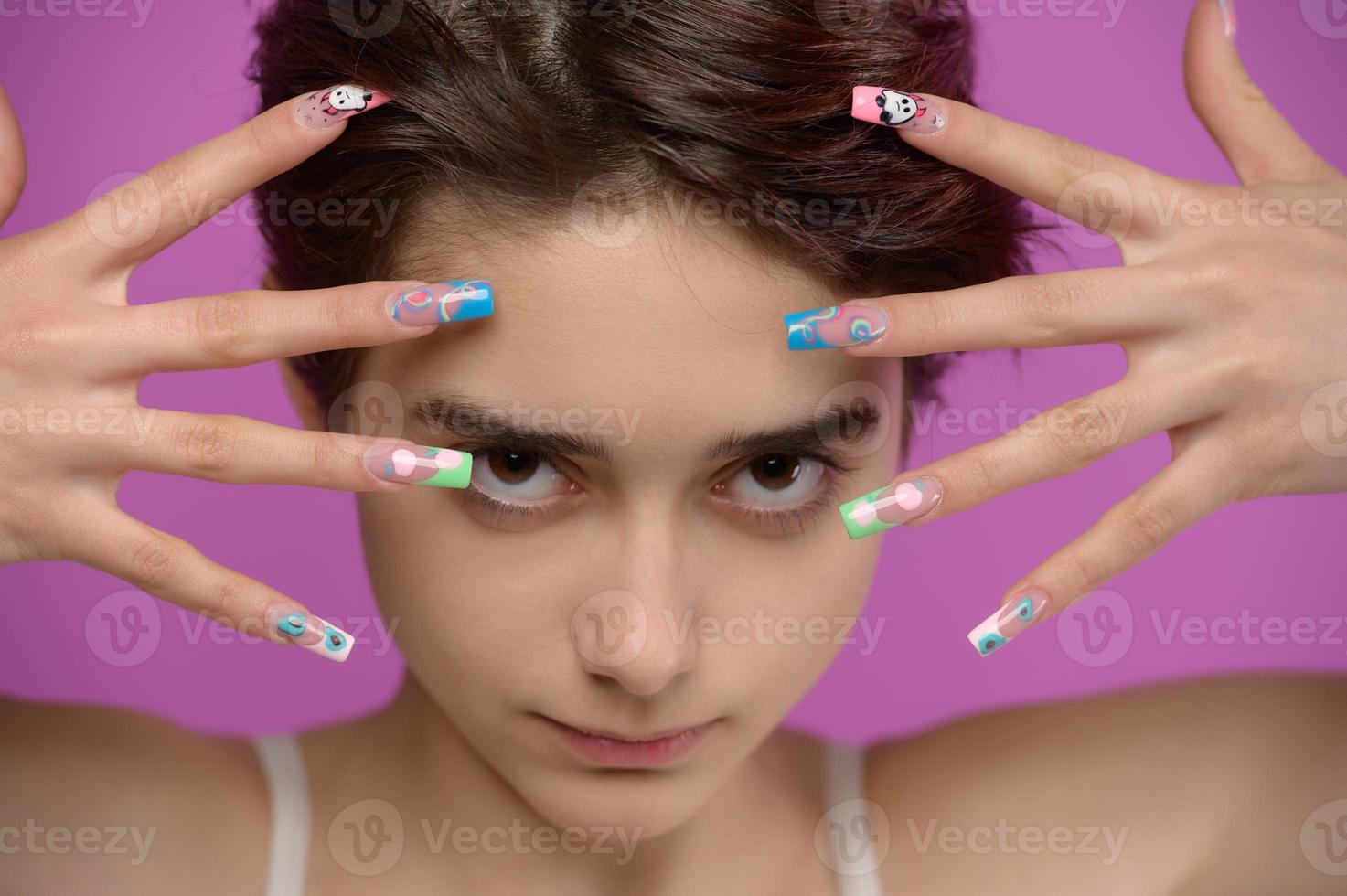 chica guapa con corte de pelo corto y arte de uñas extravagante foto