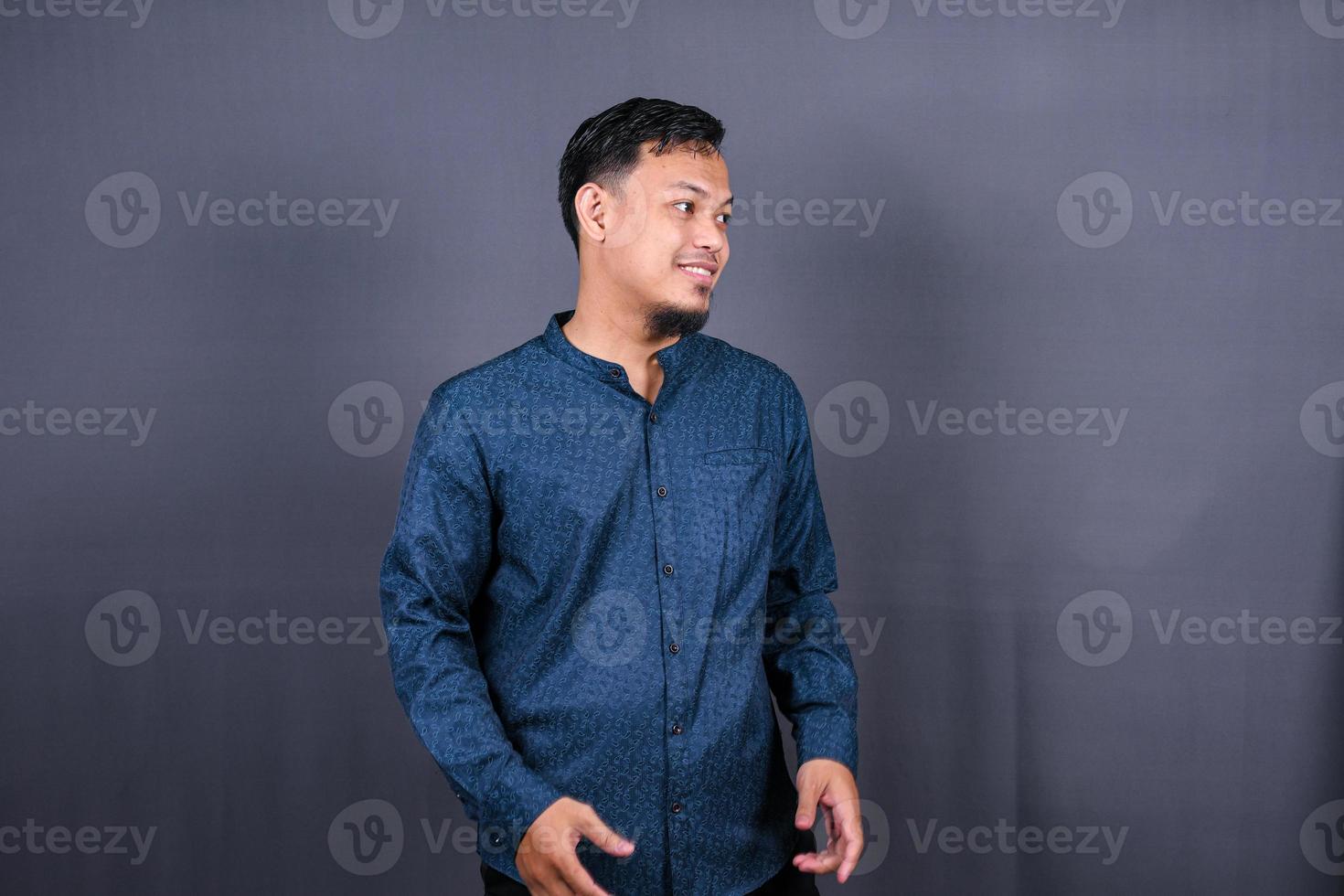 Young handsome asian man over gray background Smiling relaxed and cheerful Success and optimistic photo