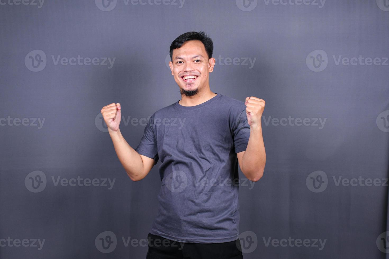 Young handsome asian man over gray background Smiling relaxed and cheerful Success and optimistic photo