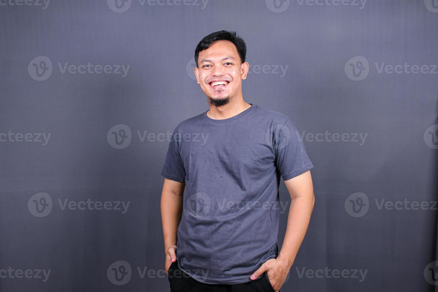 Young handsome asian man over gray background Smiling relaxed and cheerful Success and optimistic photo