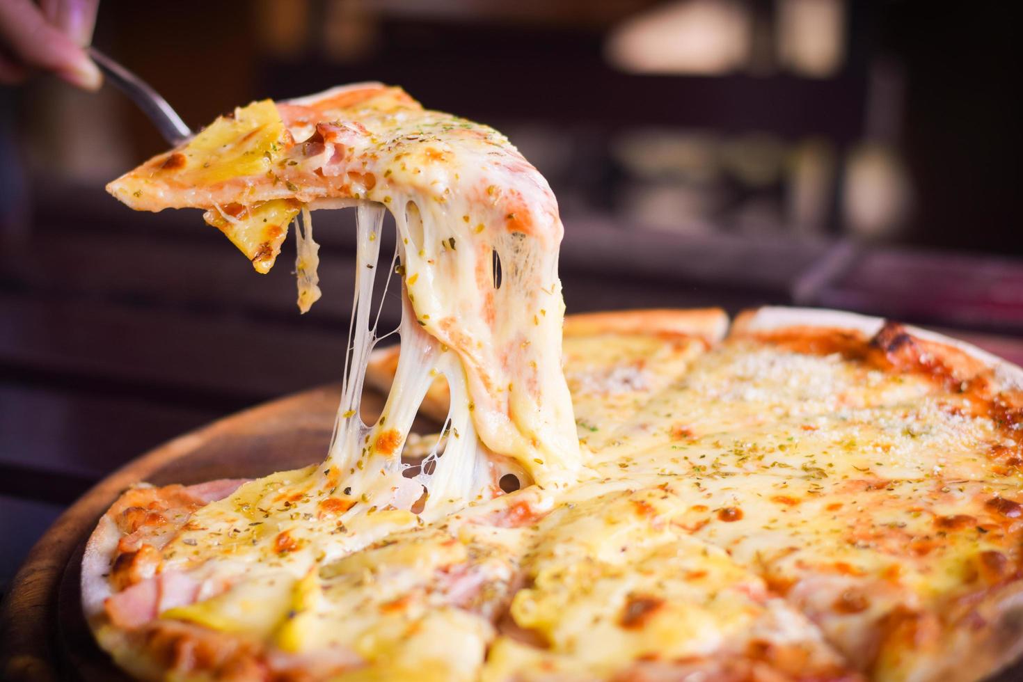 pizza de queso hawaiano sobre mesa de madera. concepto de comida casera foto