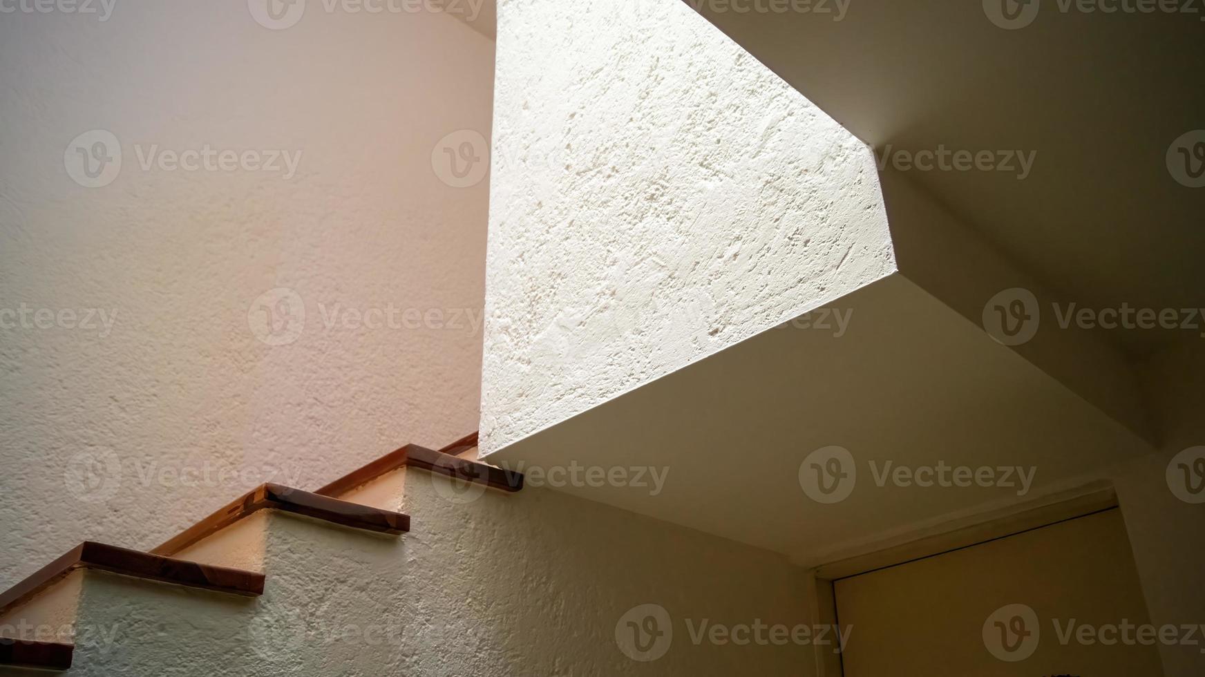 stairs and volume architecture, background, volumetry, play of light and shadows, wooden footprints and white textured walls photo