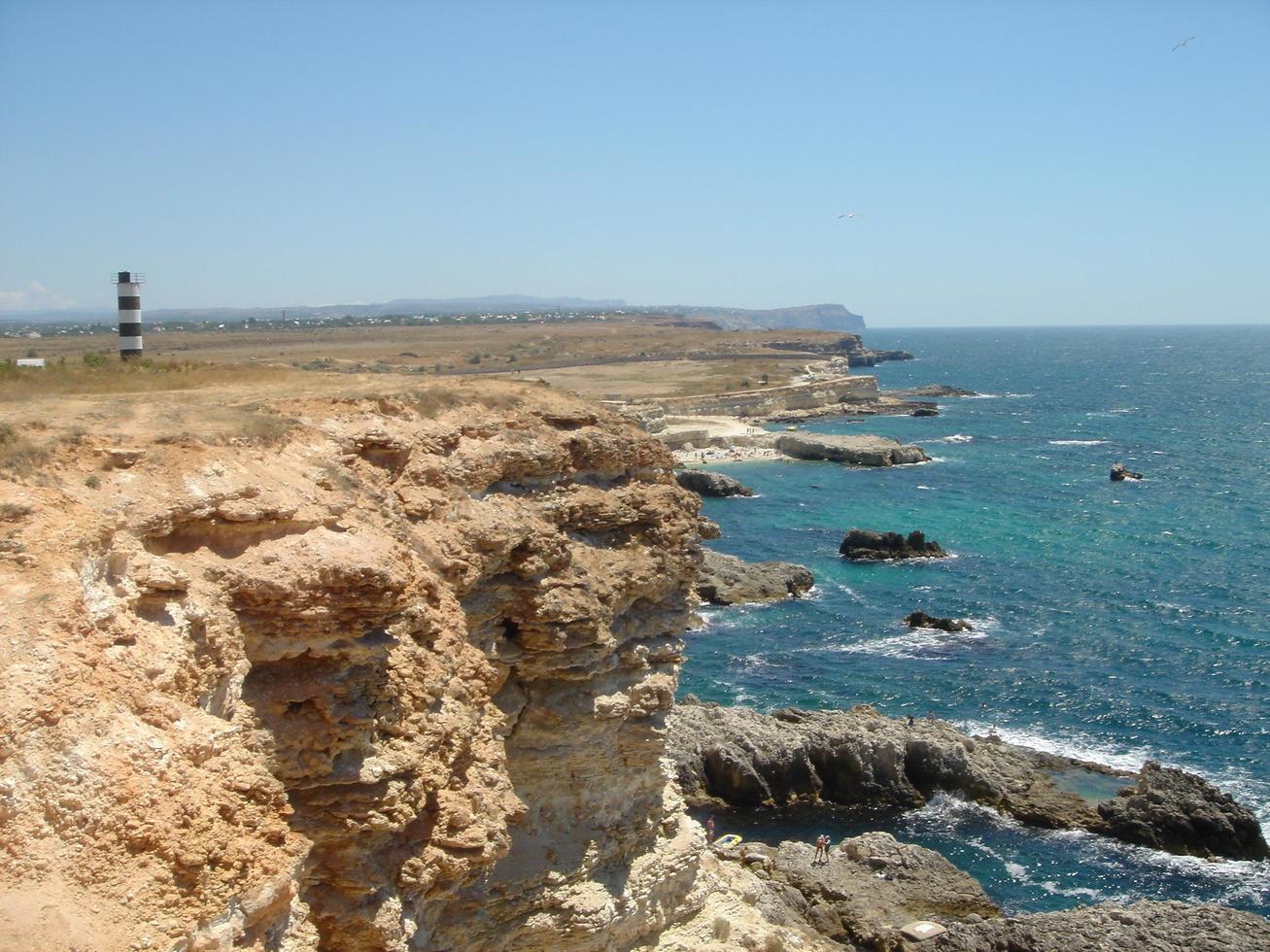 Beautiful landscape of cliff with lighthouse and sea waves in the background. photo