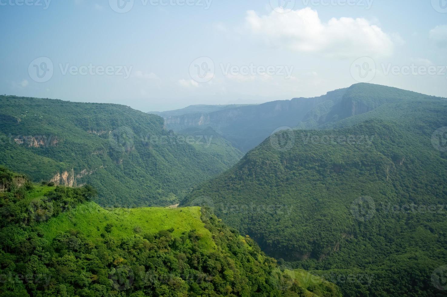 ravine trees and vegetation, view of several mountains at different depths, blue sky and few clouds, mexico photo