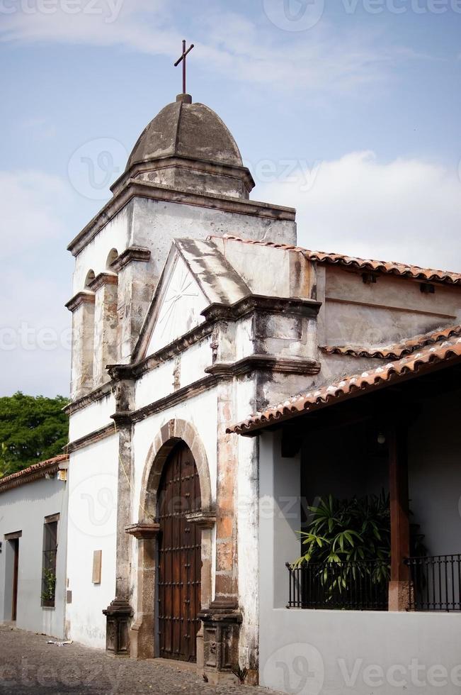 edificio antiguo de la capilla, iglesia del pueblo, paredes de arquitectura colonial, puerta de madera envejecida foto