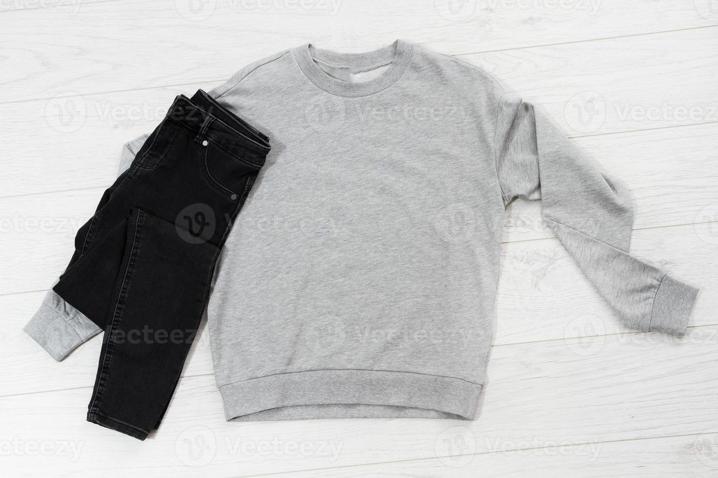 Close up gray blank template sweatshirt hoodie with copy space. Top view mockup pullover on white wooden background. Casual outfit. Flat lay template clothes. photo