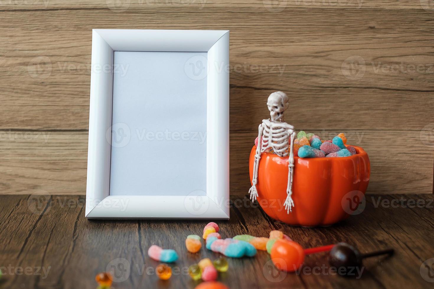 Orange pumpkin bowl and candies on table and frame with copy space for text. Happy Halloween day, Hello October, fall autumn season, Festive, party and holiday concept photo