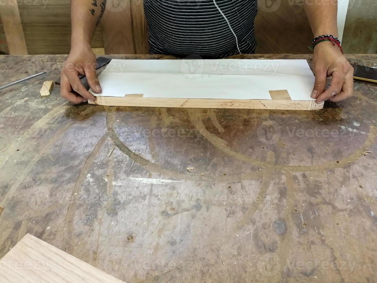 An Anonymous Carpenter Working on New Project at his Workshop. Table top view of unrecognizable man drawing n photo