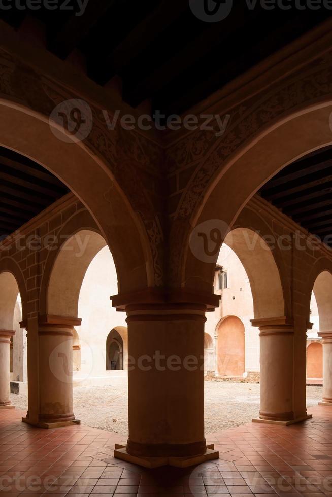 colonial architecture, arches surrounded by vegetation, play of light and shadows inside the space, natural materials photo