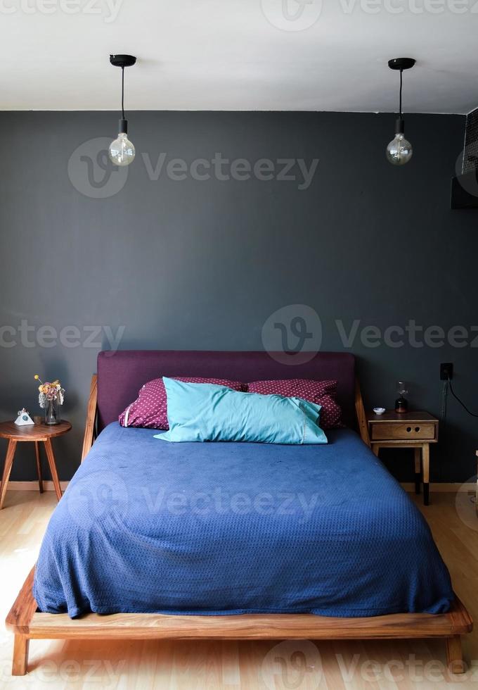 bed base, bedroom with mat on the floor, clay pot in the background, wooden credenza and mirror. photo