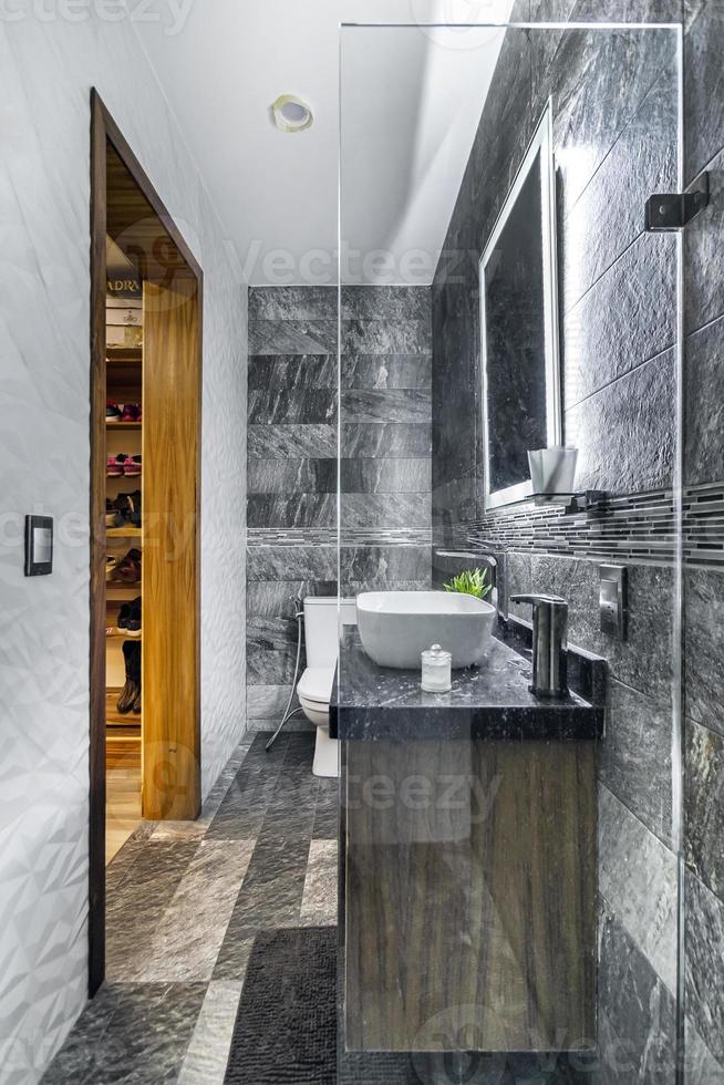 bathroom with luxury finishes, main mirror with led light from behind, white ceramic washbasin photo