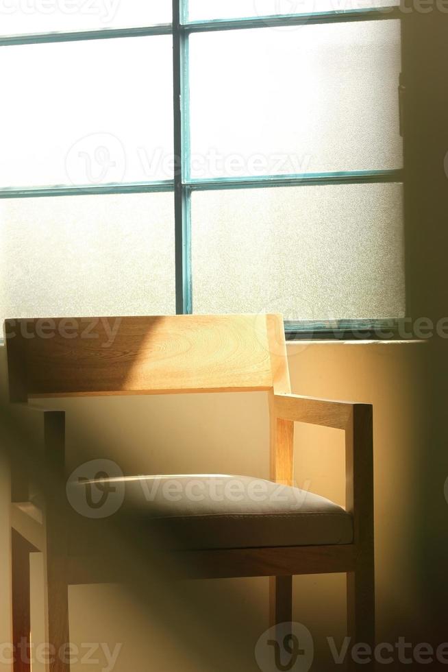 A chair modern wood frame with wooden, sunlight coming through the window illuminating the chair photo