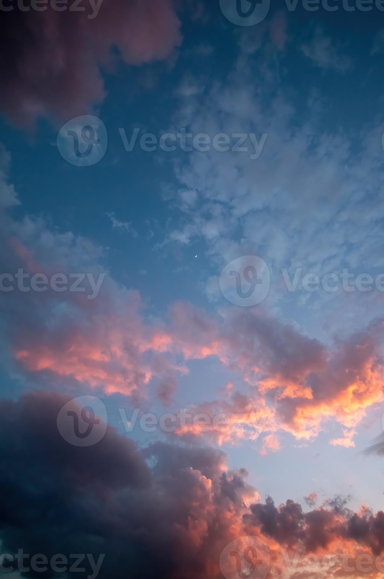 dramatic night sky, with moon and sun bathing the clouds with light