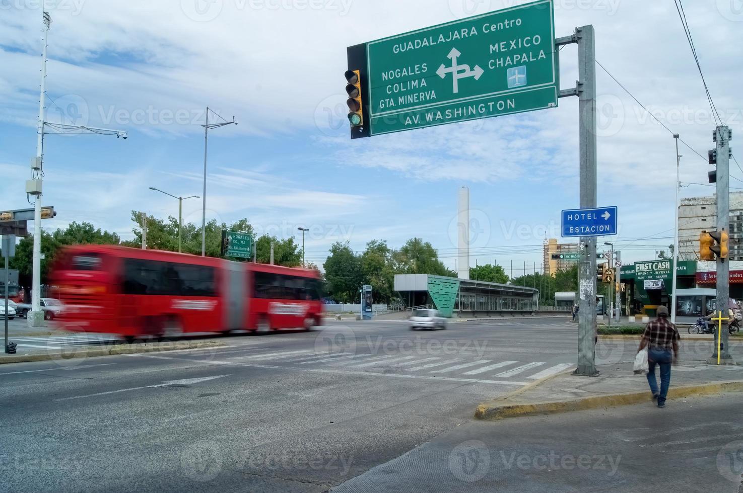 two people crossing the street with a yellow cross, in the background the city photo