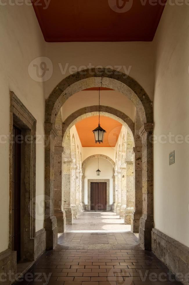 colonial architecture, arches surrounded by vegetation, play of light and shadows inside the space, natural materials photo