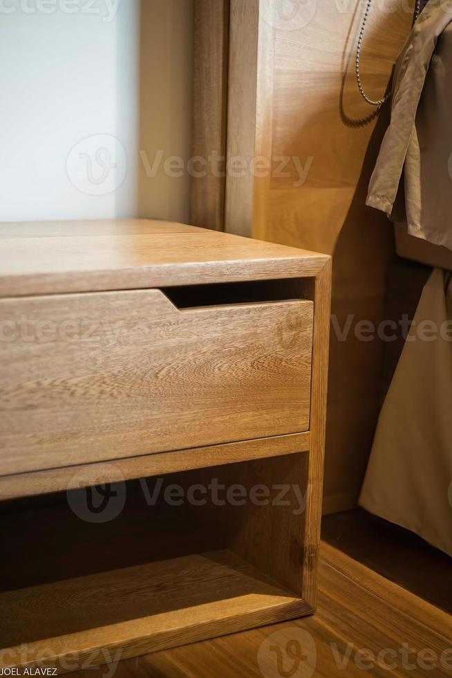 wooden bureau on top of a rug, side table, night table photo