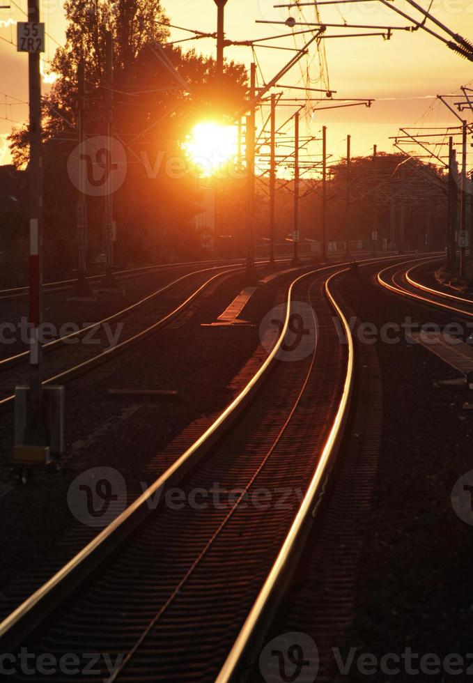 The sun sets over some train tracks in Cologne, Germany photo