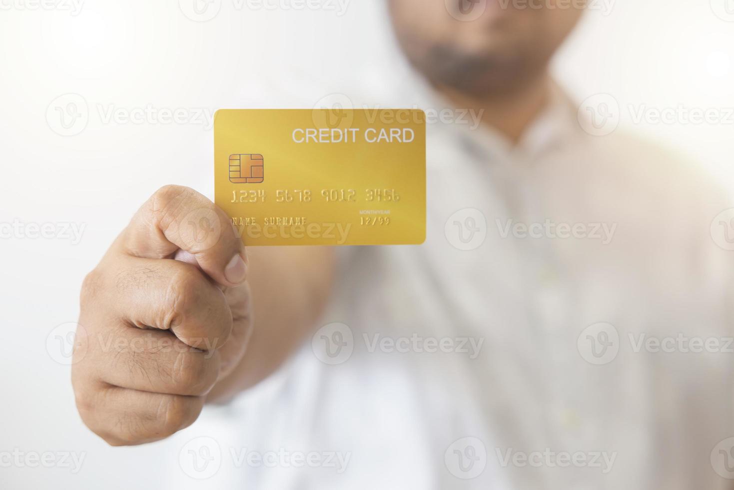 Close-up hand of Asian man holding yellow gold credit card in his hand. isolated on white background. Concept of finance, trading, communication, social, technology, business photo