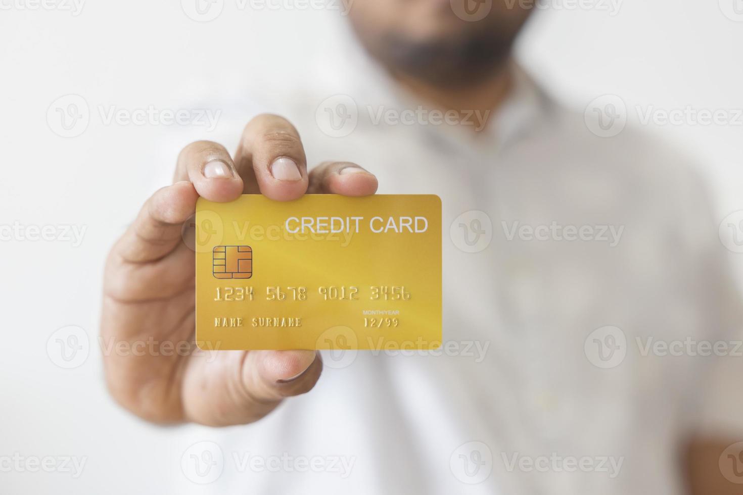 Close-up hand of Asian man holding yellow gold credit card in his hand. isolated on white background. Concept of finance, trading, communication, social, technology, business photo