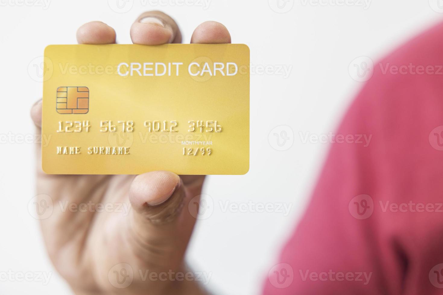 mano de primer plano de un hombre asiático con tarjeta de crédito de oro amarillo en la mano. aislado sobre fondo blanco. concepto de finanzas, comercio, comunicación, social, tecnología, negocios foto