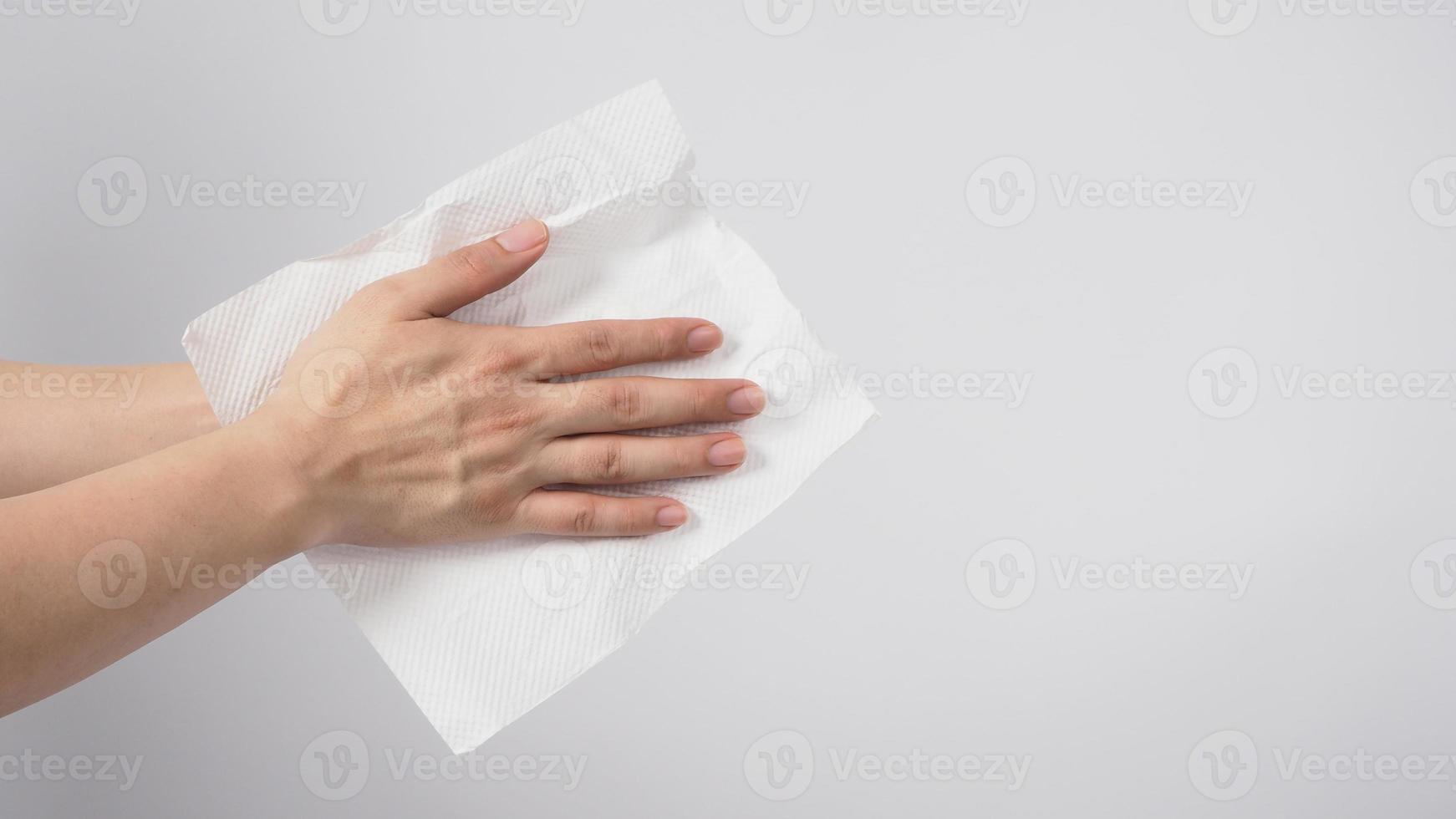 Male model is dry hands thoroughly with tissue paper on white background. photo