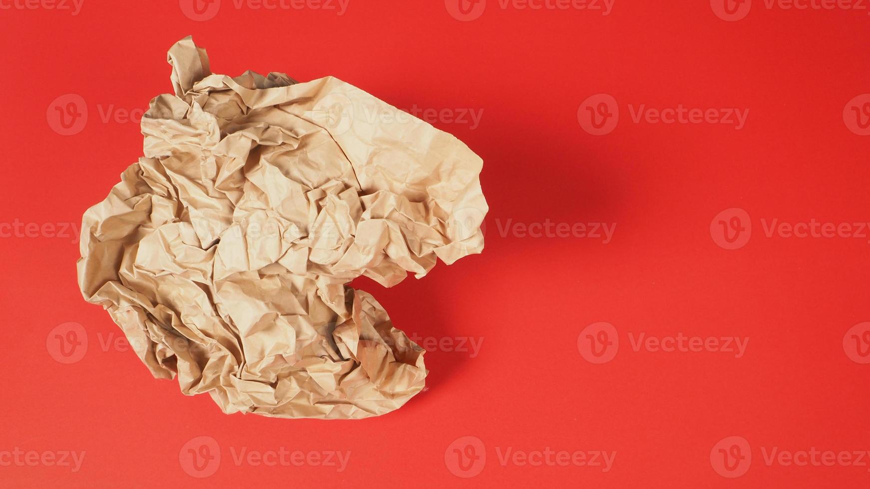 Crumpled brown paper.It is mauled on red background. photo