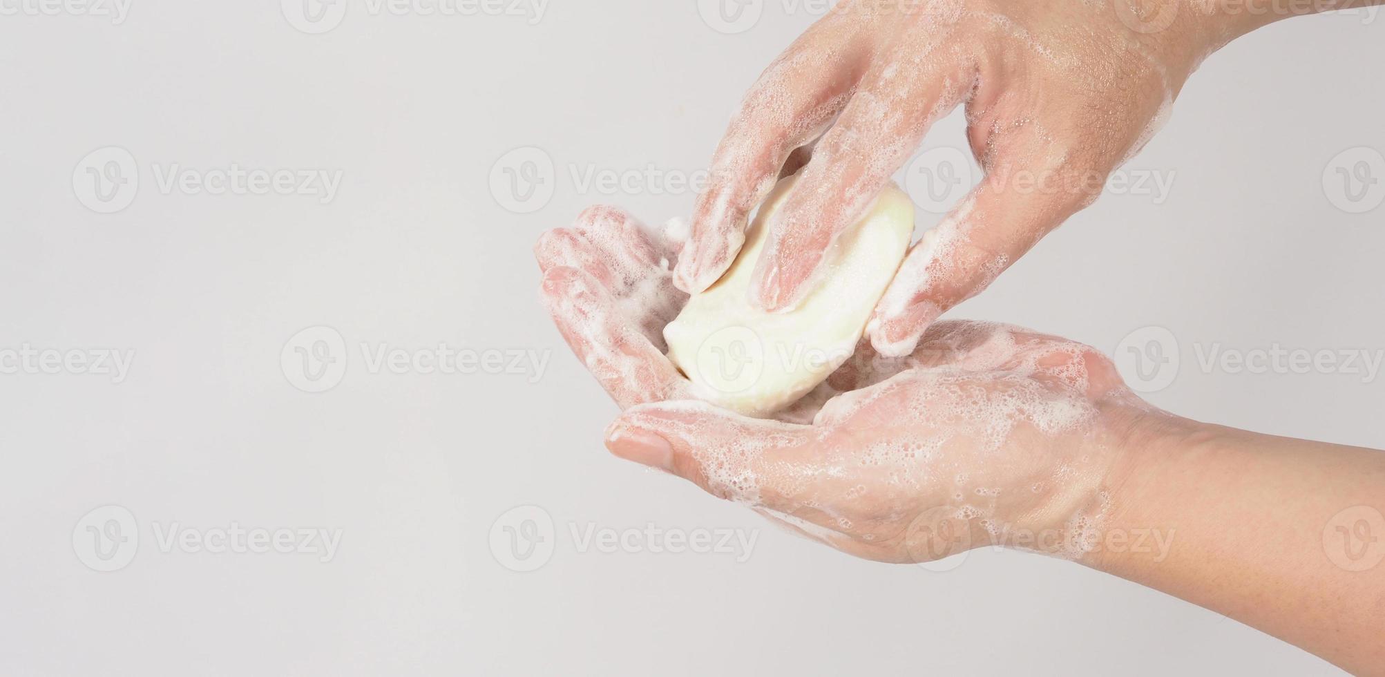 gesto de lavado de manos con jabón de barra y burbuja de espuma sobre fondo blanco. foto