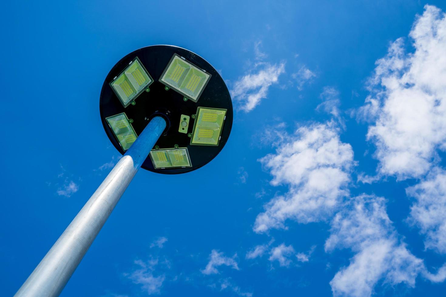 fondo de cielo azul claro solar con nubes blancas en un día despejado, lámpara de células solares y energía alternativa del sol. foto