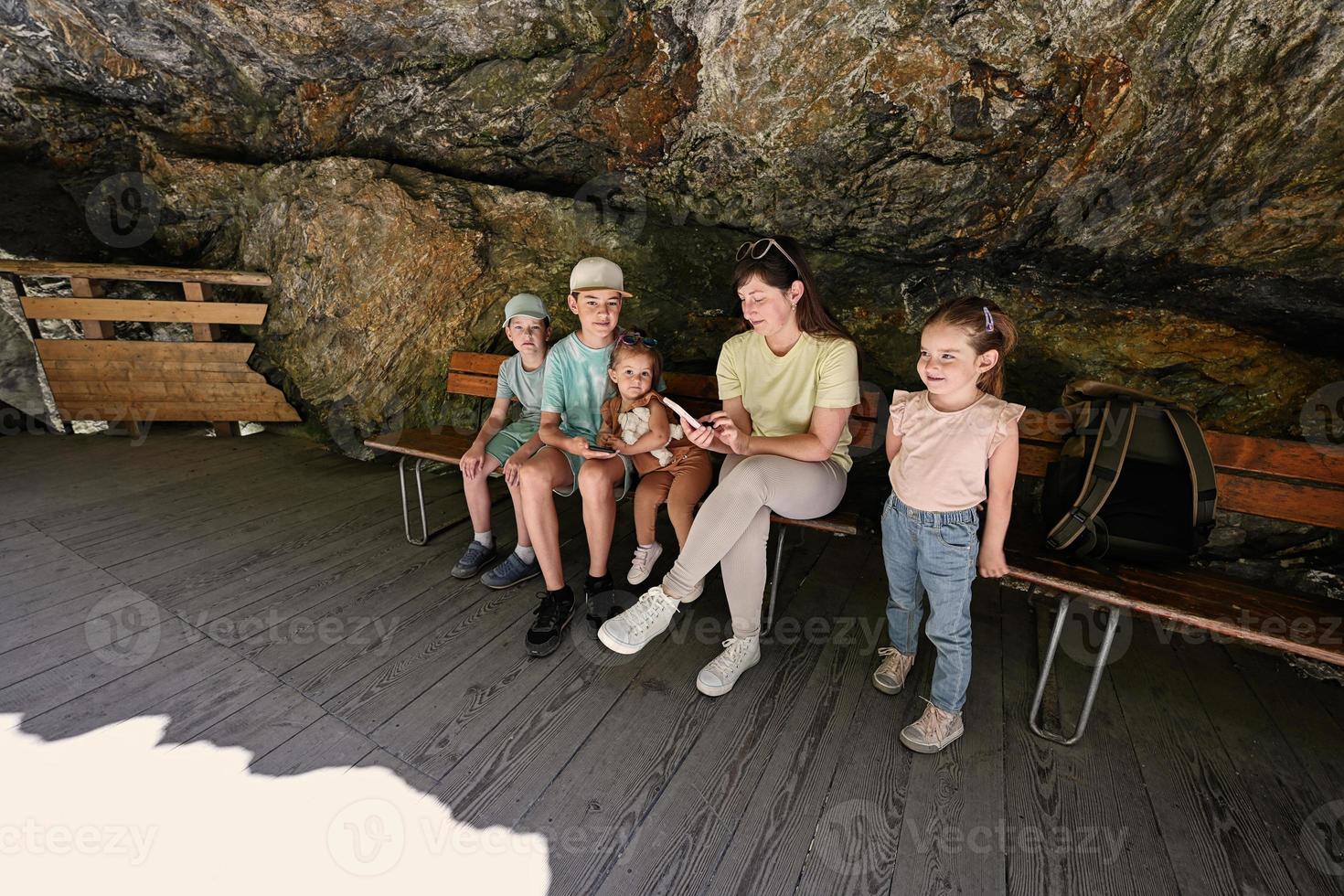 Mother with children sit on bench in Liechtensteinklamm or Liechtenstein Gorge, Austria. photo