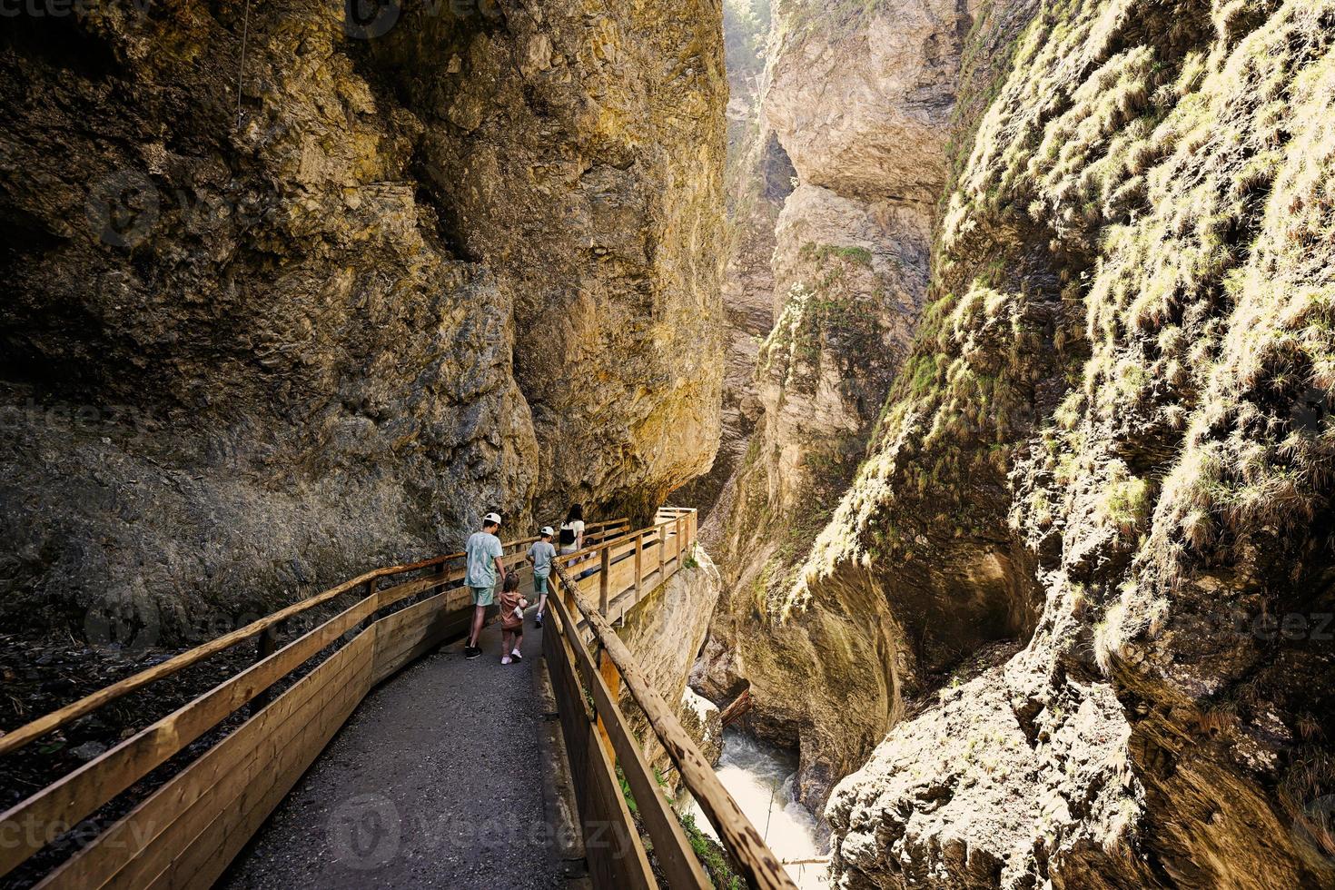 Mother hikking with four kids in Liechtensteinklamm or Liechtenstein Gorge, Austria. photo