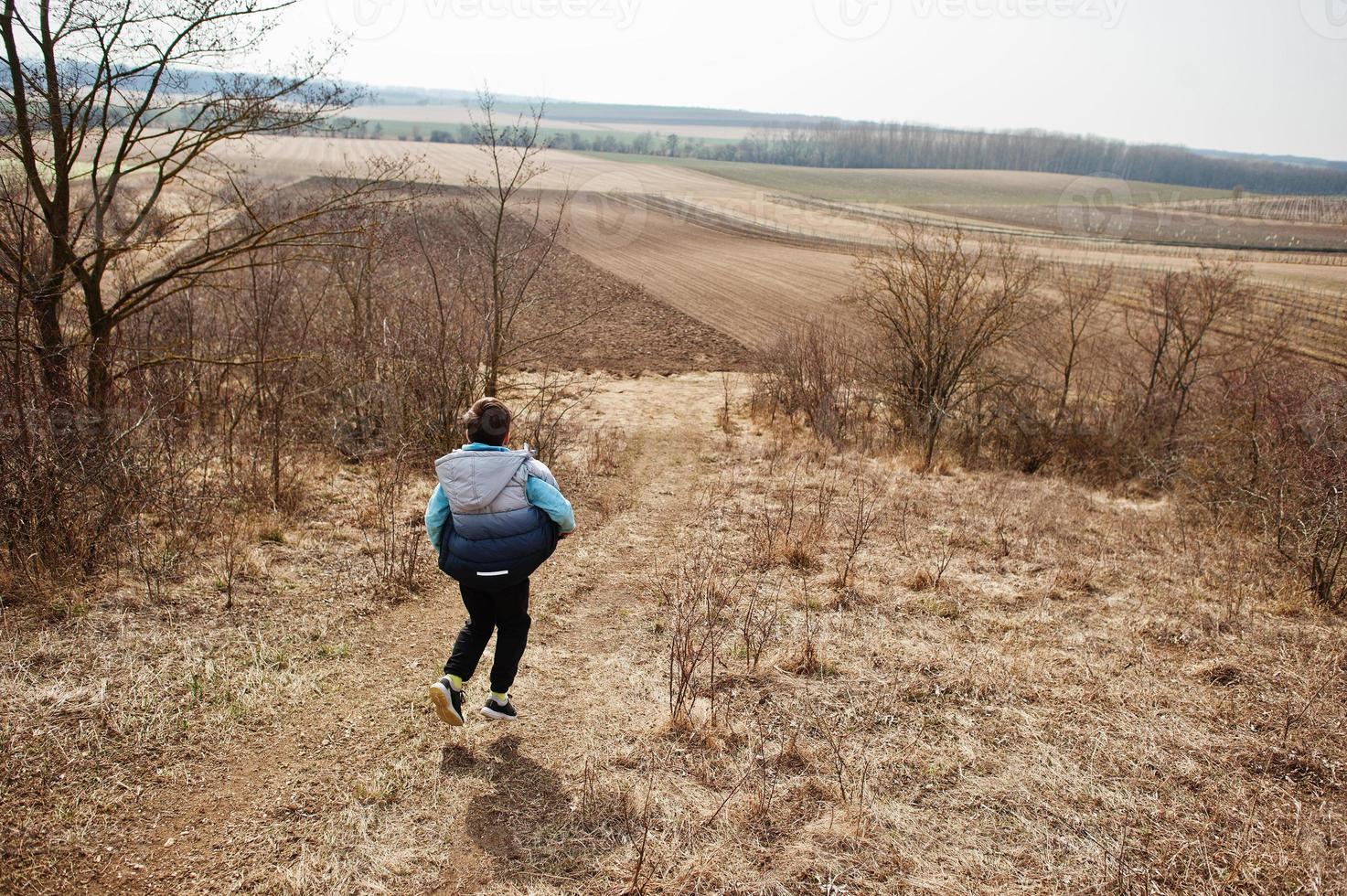 Boy running on field in early spring. photo