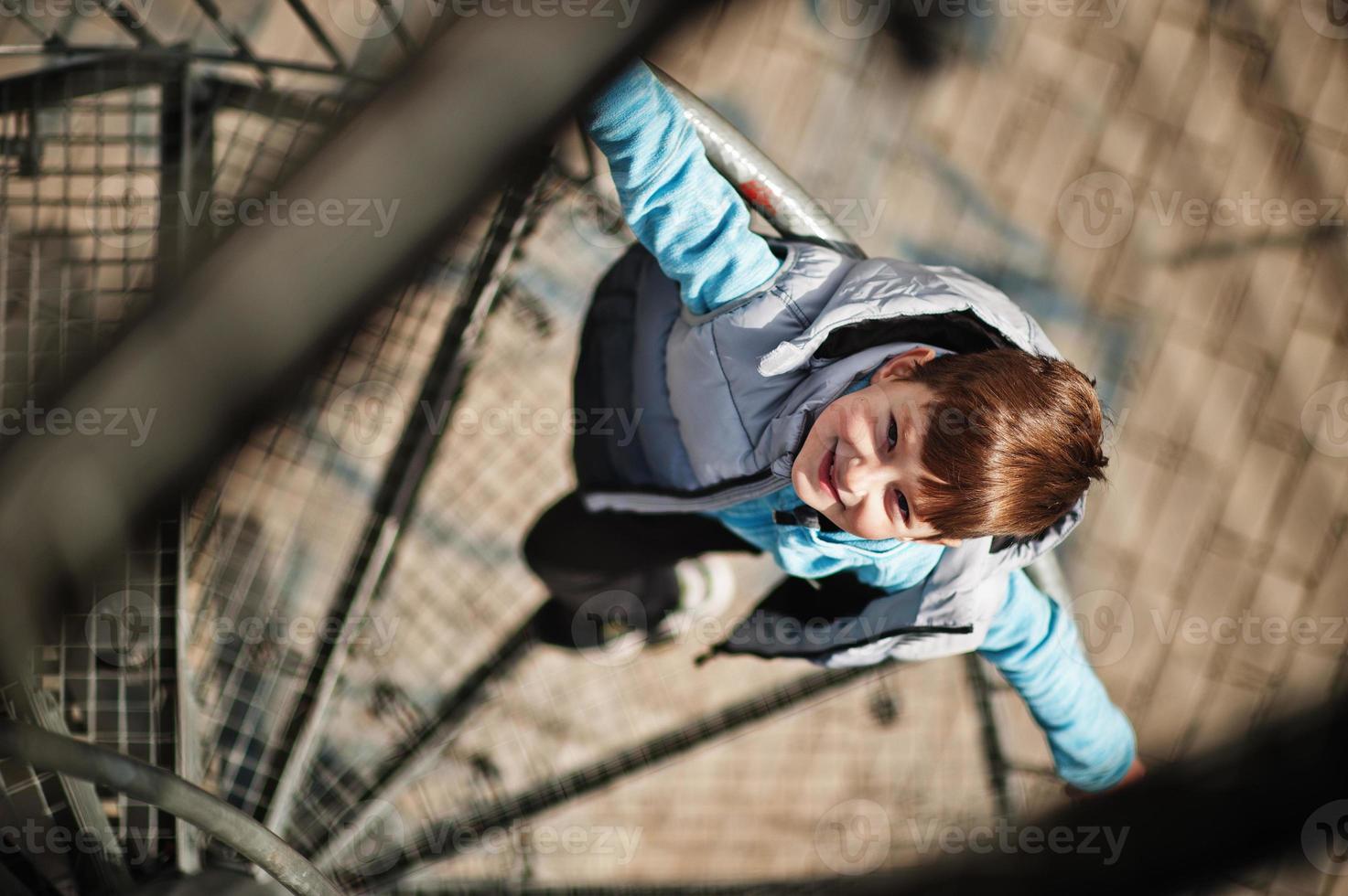 niño de pie en la escalera de caracol en la torre de observación. foto