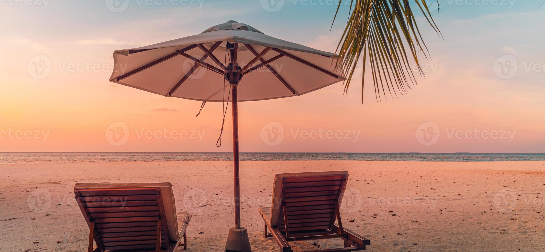 hermosa playa panorámica. sillas sombrilla playa de arena, paisaje marino de hojas de palma. turismo de vacaciones de verano. increíble paisaje tropical. paisaje tranquilo, playa relajante, paisaje tropical panorama foto