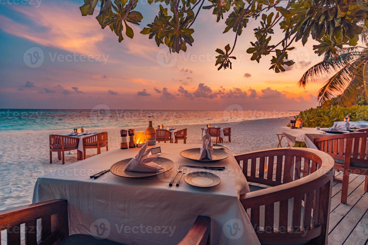 Outdoor restaurant at the beach. Table setting at tropical beach restaurant. Led light candles