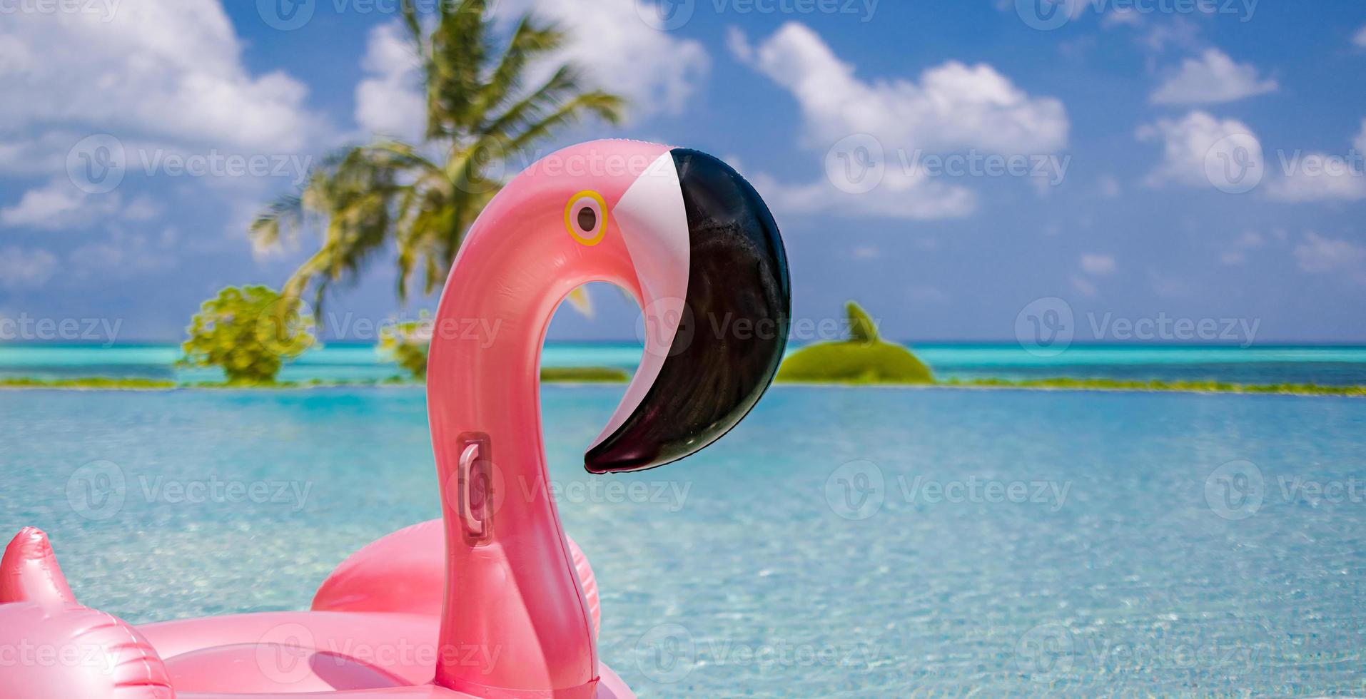 Summer swimming pool with inflatable pink flamingo, luxury resort hotel poolside. Happy blue cloudy sky, tropical paradise island infinity pool sea view. Vacation, holiday fun landscape. Relax leisure photo