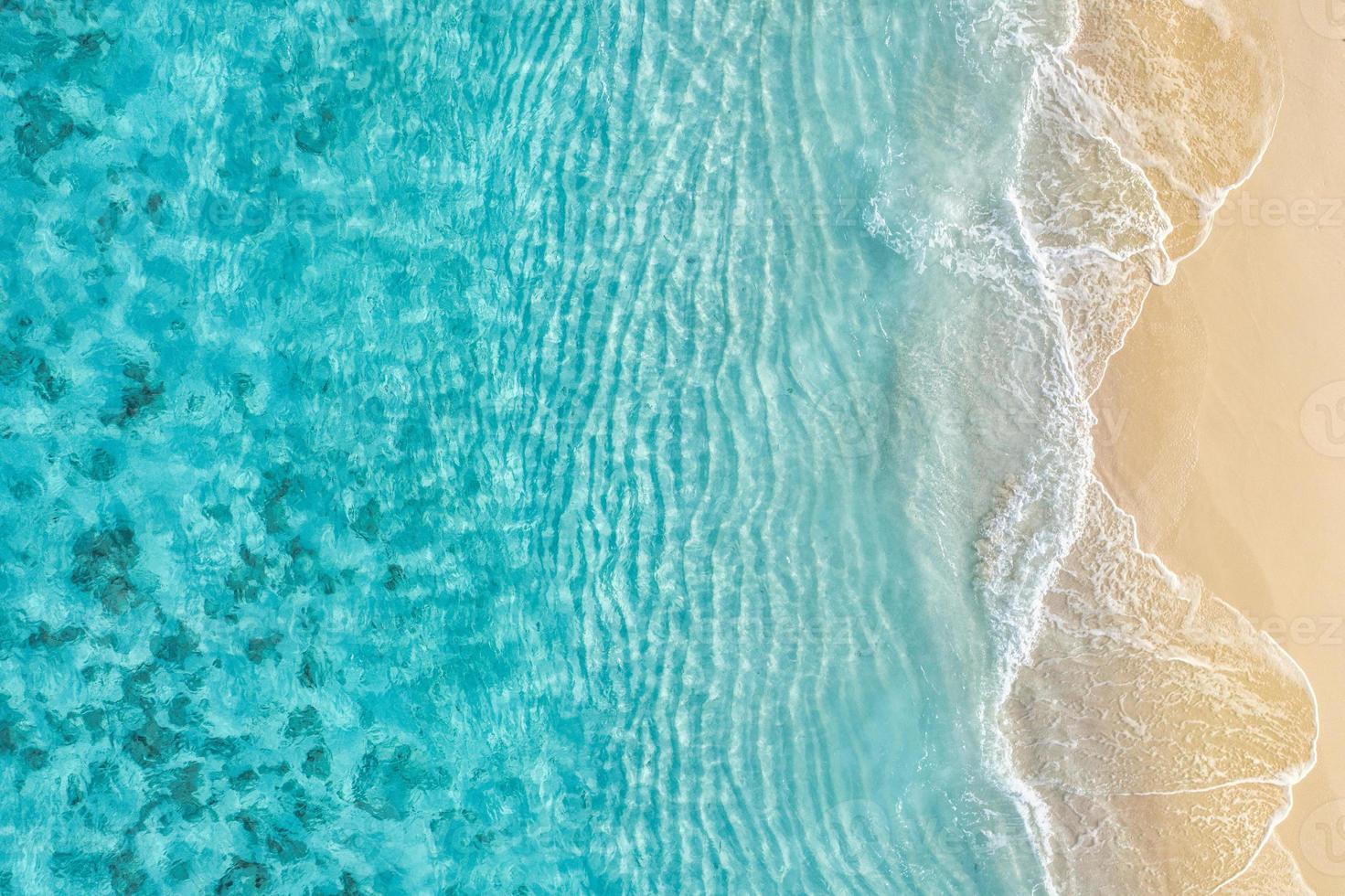 Summer seascape beautiful waves, blue sea water in sunny day. Top view from drone. Sea aerial view, amazing tropical nature background. Beautiful bright sea with waves splashing and beach sand concept photo