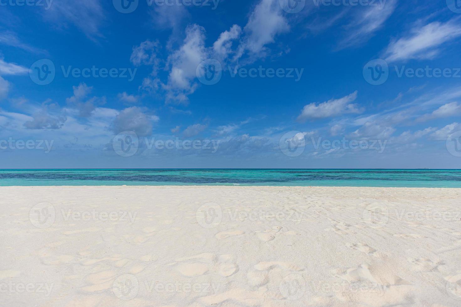 Closeup sandy beach waves and blue summer sky. Panoramic beach landscape. Empty tropical beach and seascape, horizon. Bright blue sky, soft sand, calmness, tranquil seaside relaxing sunlight, summer photo