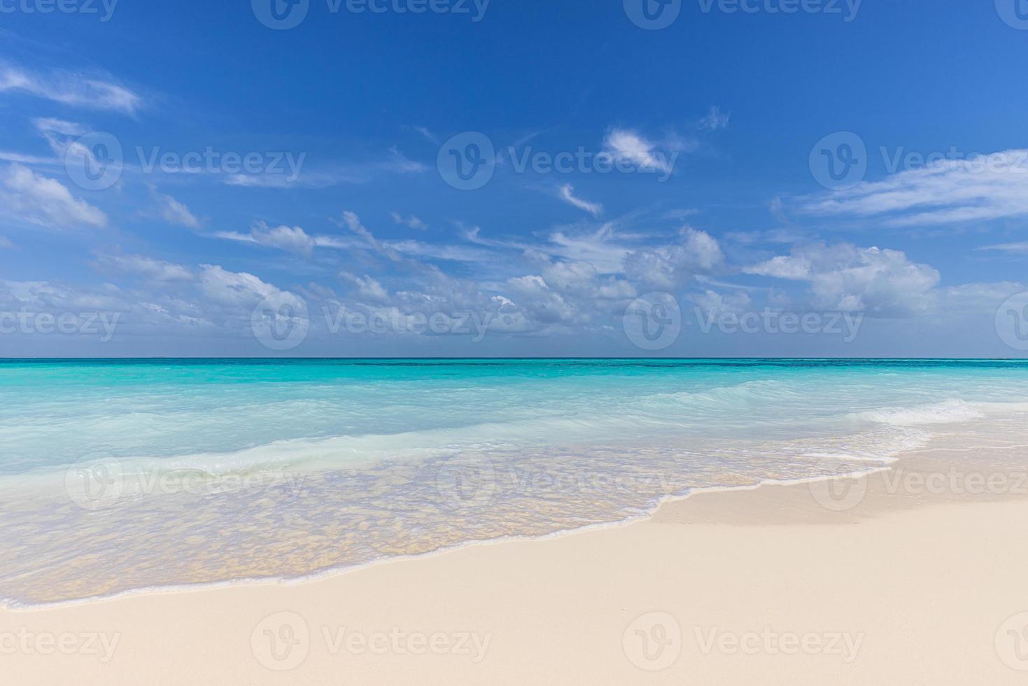 primer plano de la arena en la playa y el cielo azul de verano. paisaje panorámico de la playa. playa tropical vacía y paisaje marino. nubes de cielo azul, arena suave, calma, luz solar tranquila y relajante, estado de ánimo tranquilo de verano foto