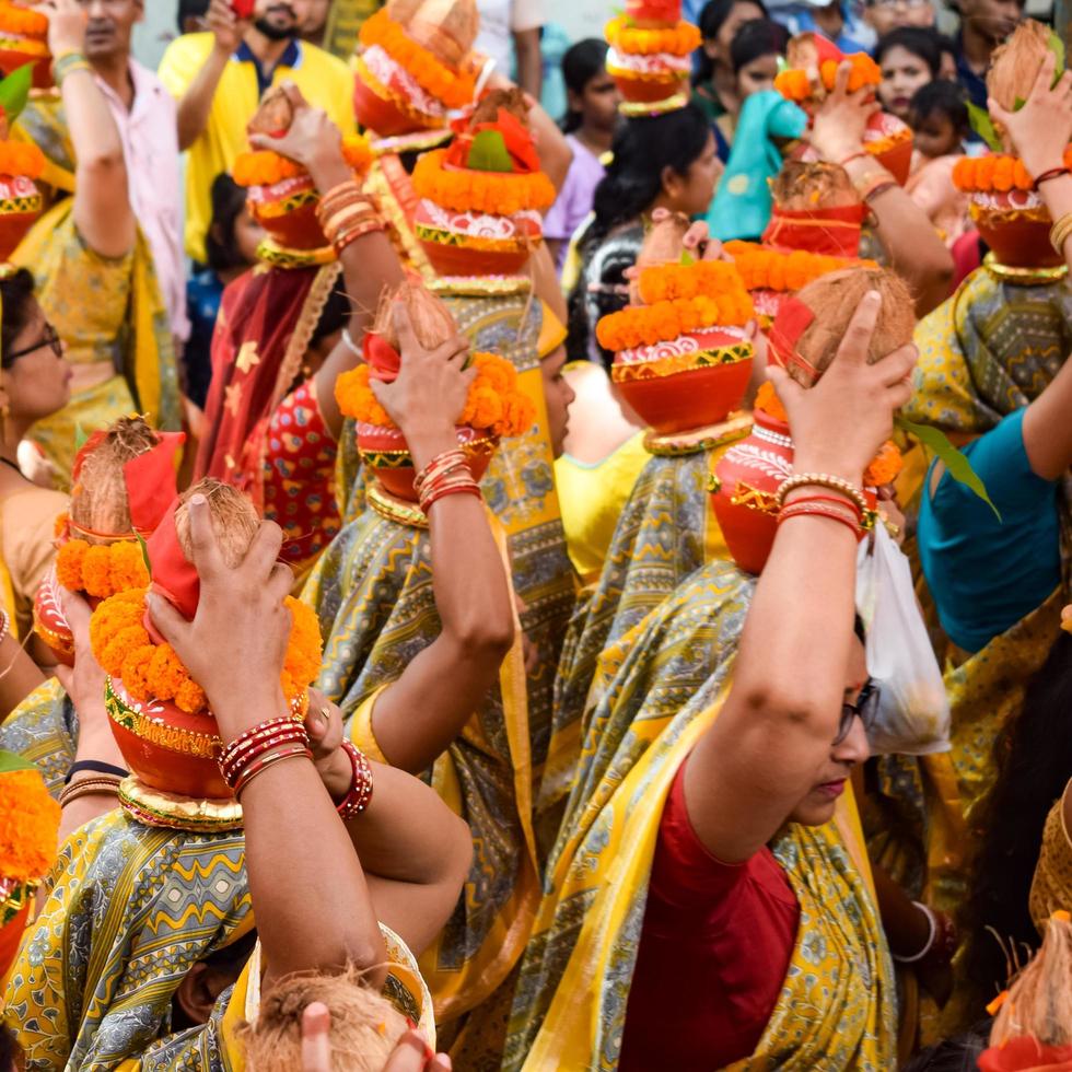 New Delhi, India April 03 2022 - Women with Kalash on head during Jagannath Temple Mangal Kalash Yatra, Indian Hindu devotees carry earthen pots containing sacred water with a coconut on top photo